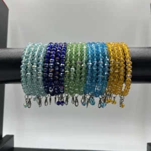 Close-up detail of emerald green and royal blue crystal beaded bangles showing faceted glass bead quality