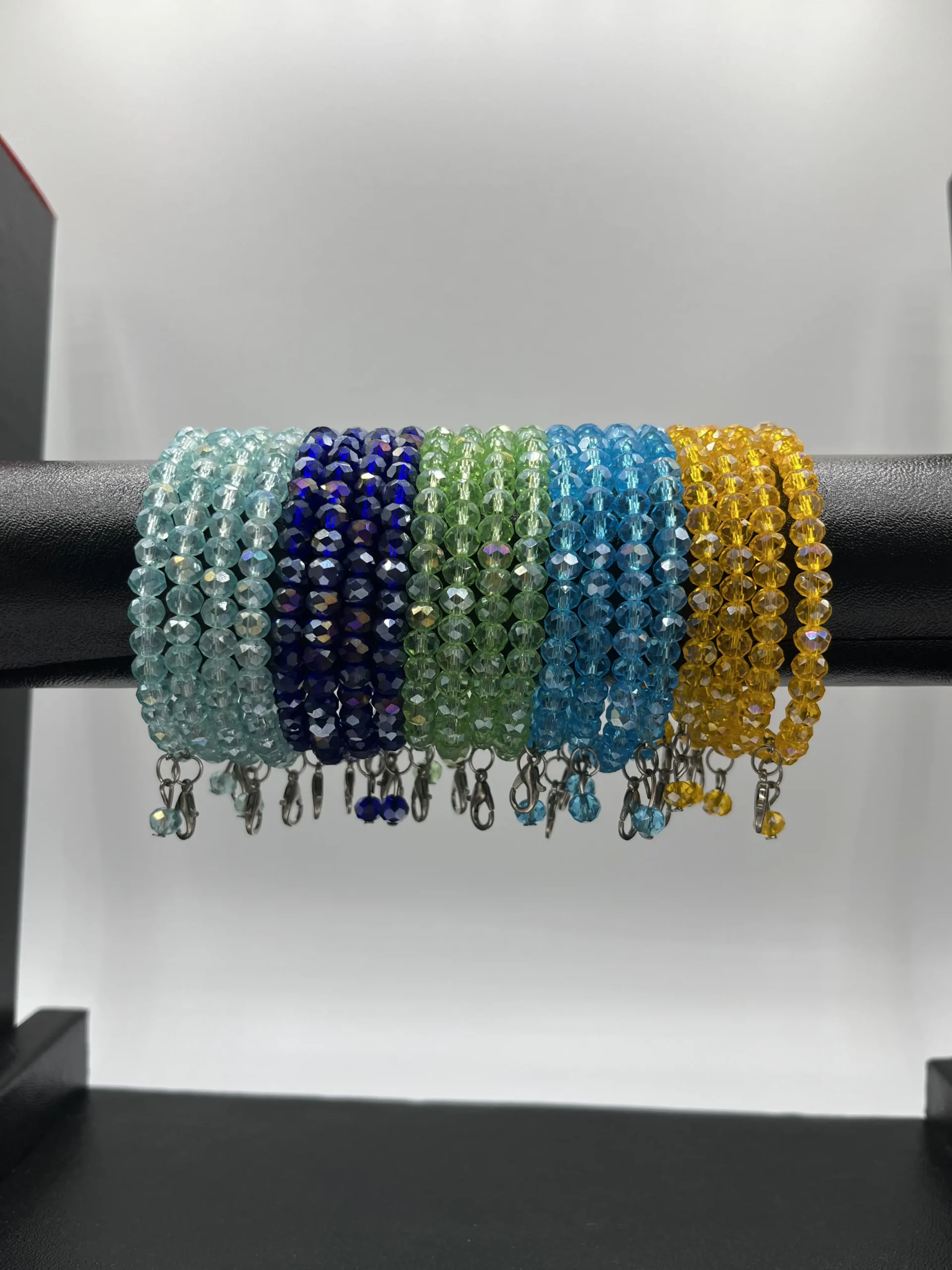 Close-up detail of emerald green and royal blue crystal beaded bangles showing faceted glass bead quality