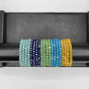 Sky blue and turquoise crystal beaded bangles stacked together on wrist showing layered jewelry styling