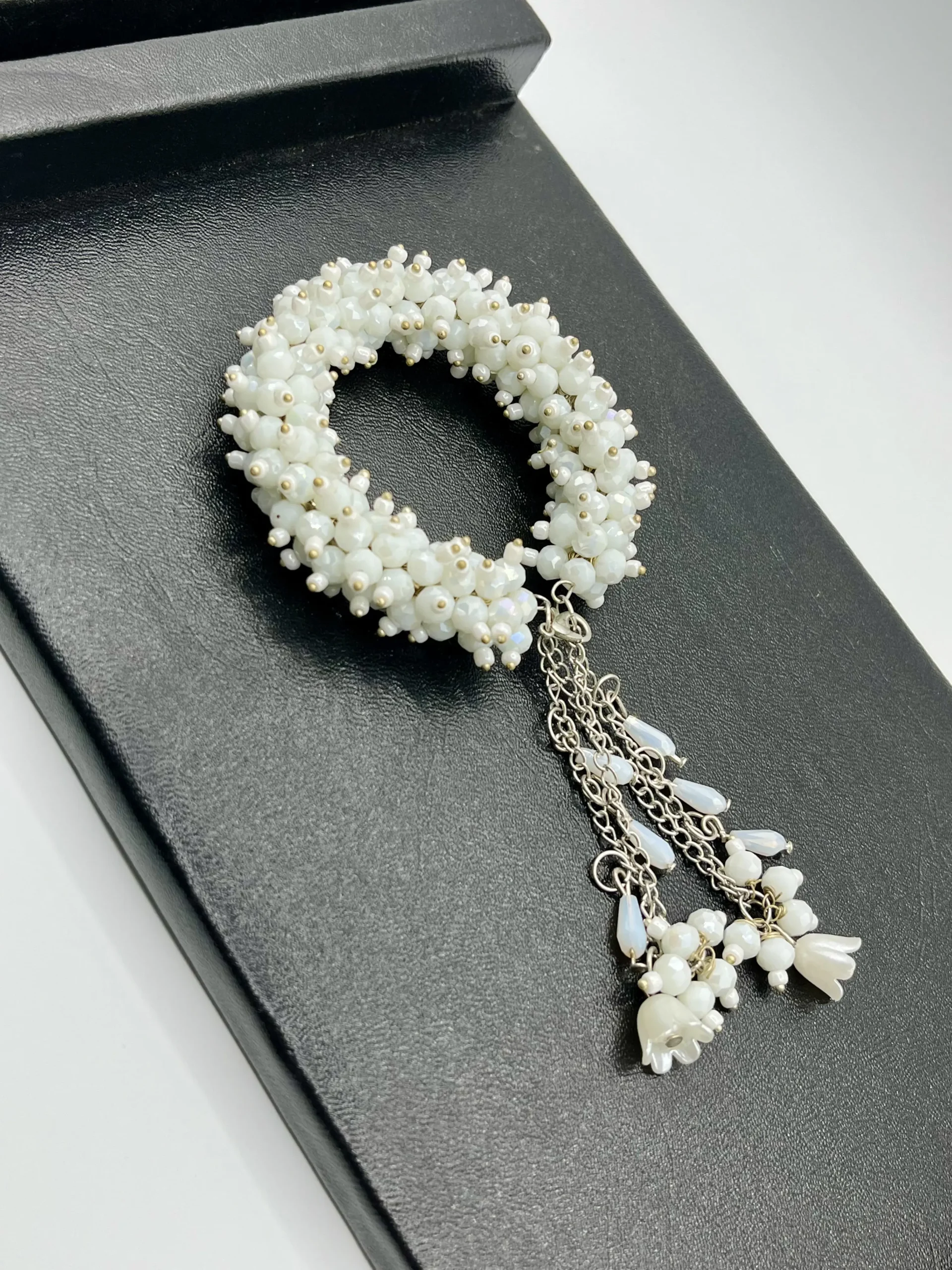 Close-up detail of white pearl beads and silver-tone alloy chains in handmade gajra bracelet showing craftsmanship