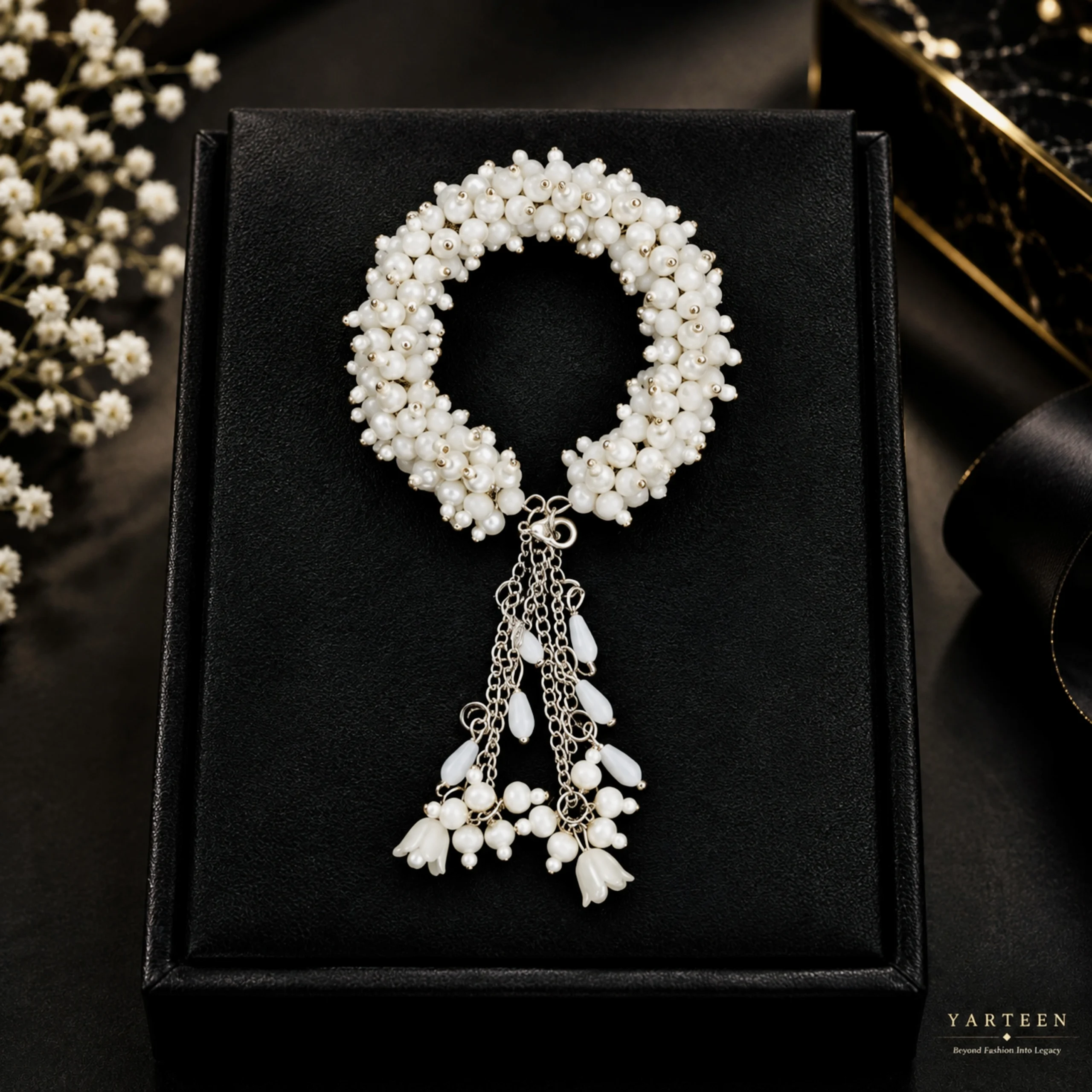Elegant handmade white pearl gajra bracelet with hanging tassel chains and floral accents for bridal celebrations