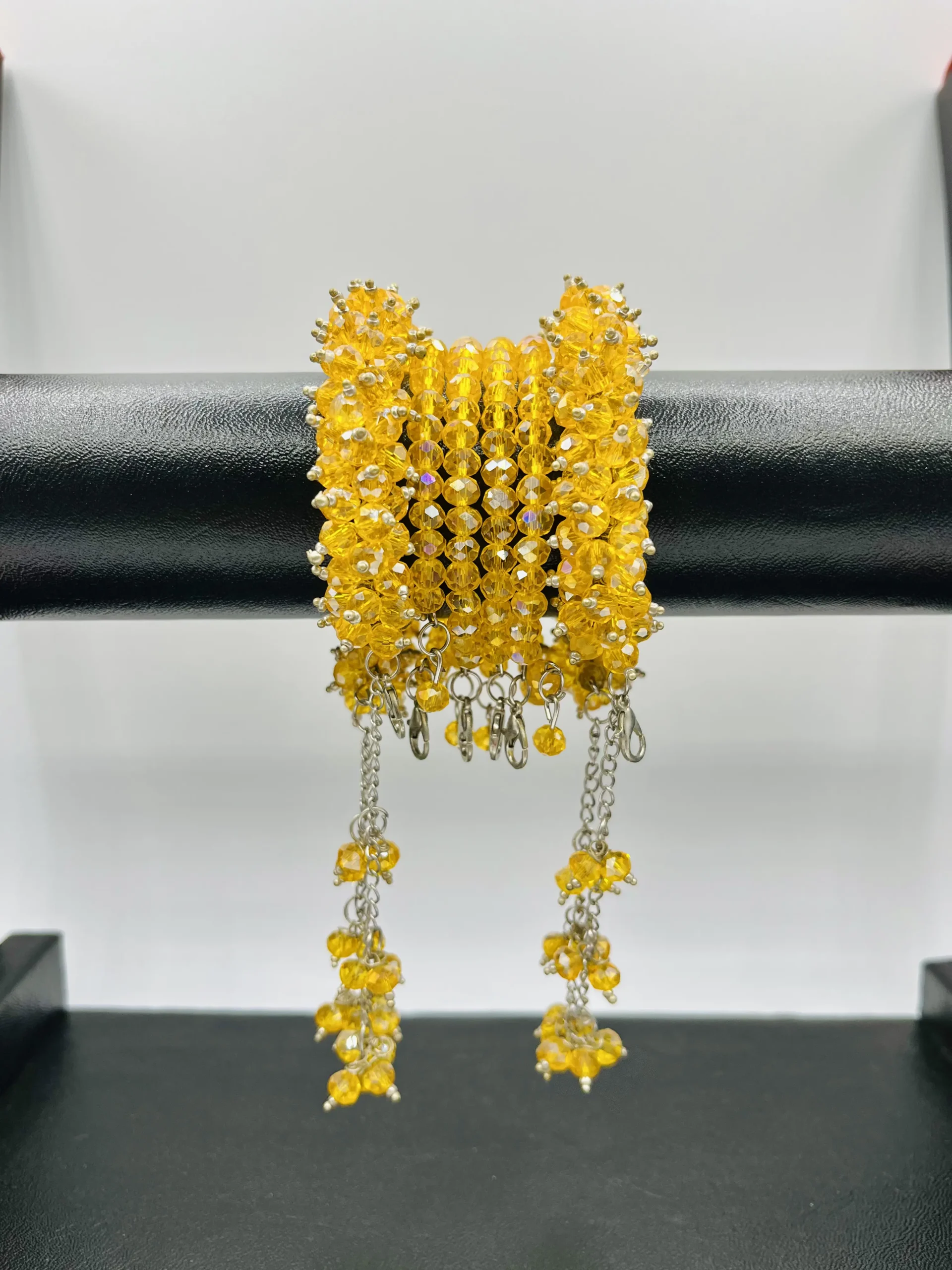 Close-up detail of yellow faceted crystal beads and silver chain accents in handmade gajra bracelet