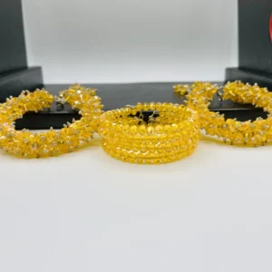 Side view of yellow crystal gajra bracelet displaying multi-layered cuff design with hanging crystal tassels