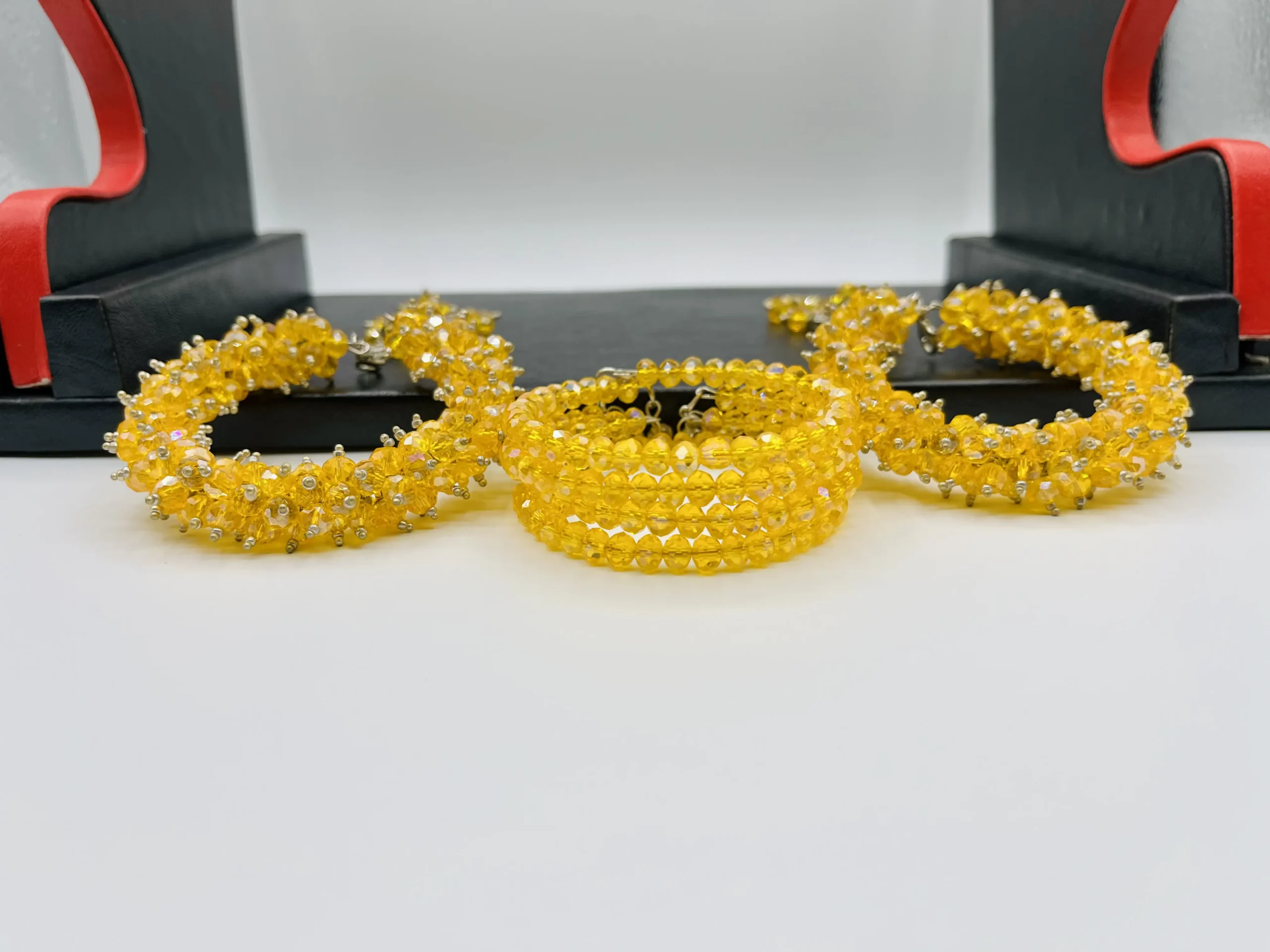 Side view of yellow crystal gajra bracelet displaying multi-layered cuff design with hanging crystal tassels